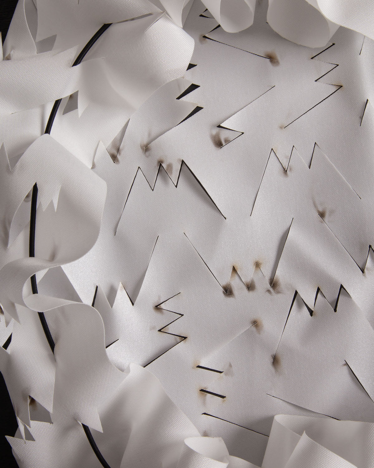 Close-up of a white Savotta backpack camo scrim with laser cut marks