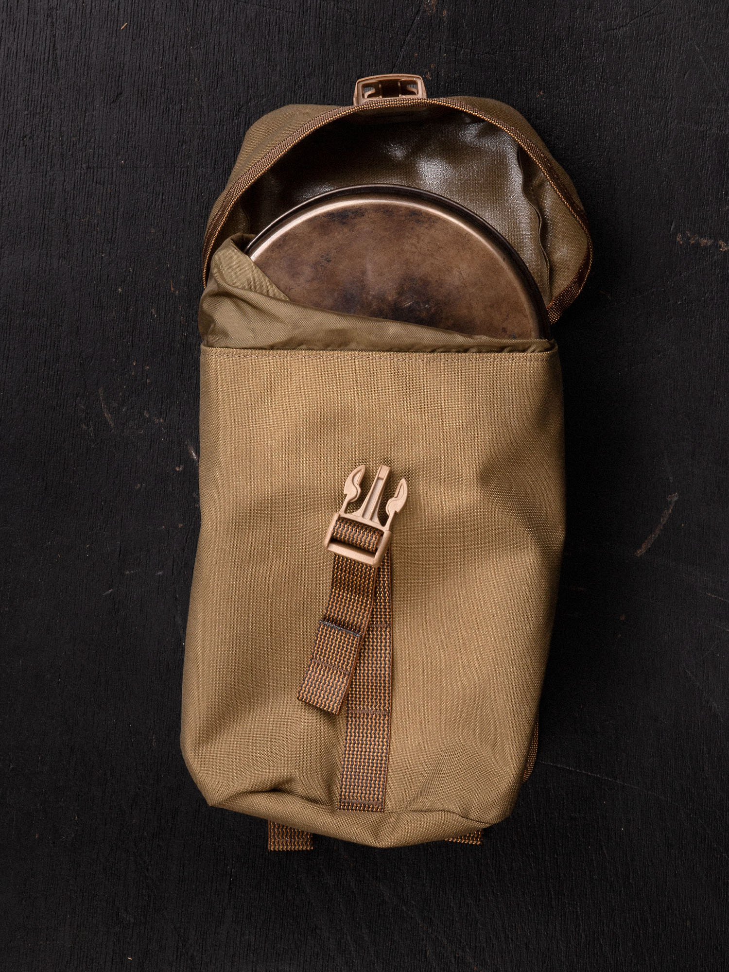 Brown Savotta lidded GP pouch 4x5 containing a metal pot on a black background