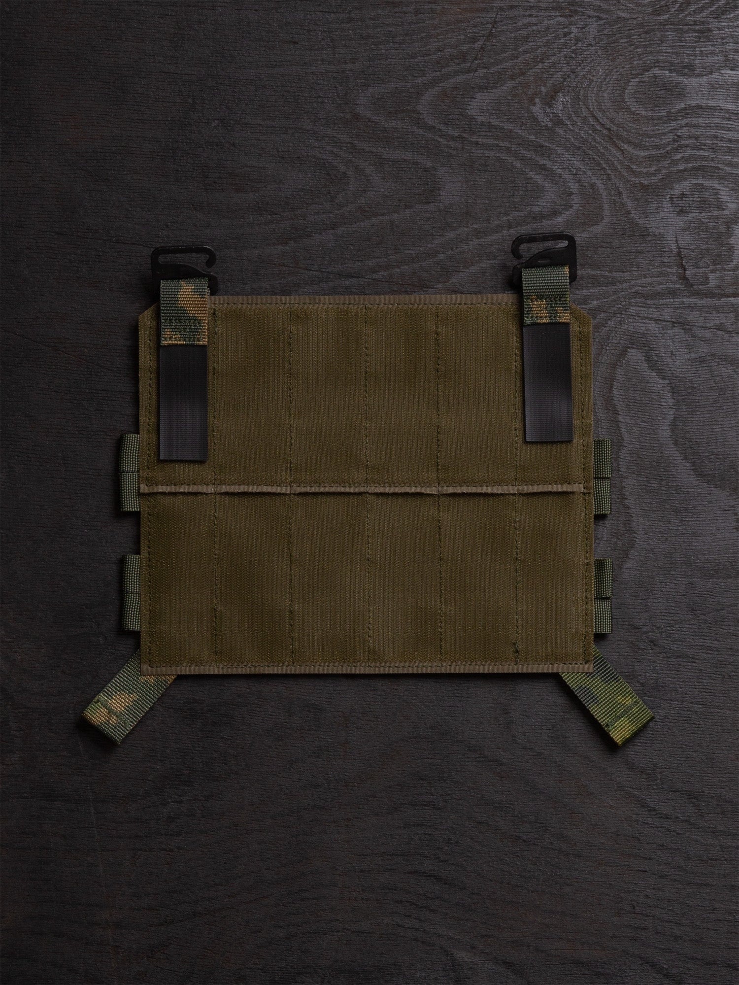 Savotta Varjelus PALS placard from the back on a dark wooden surface