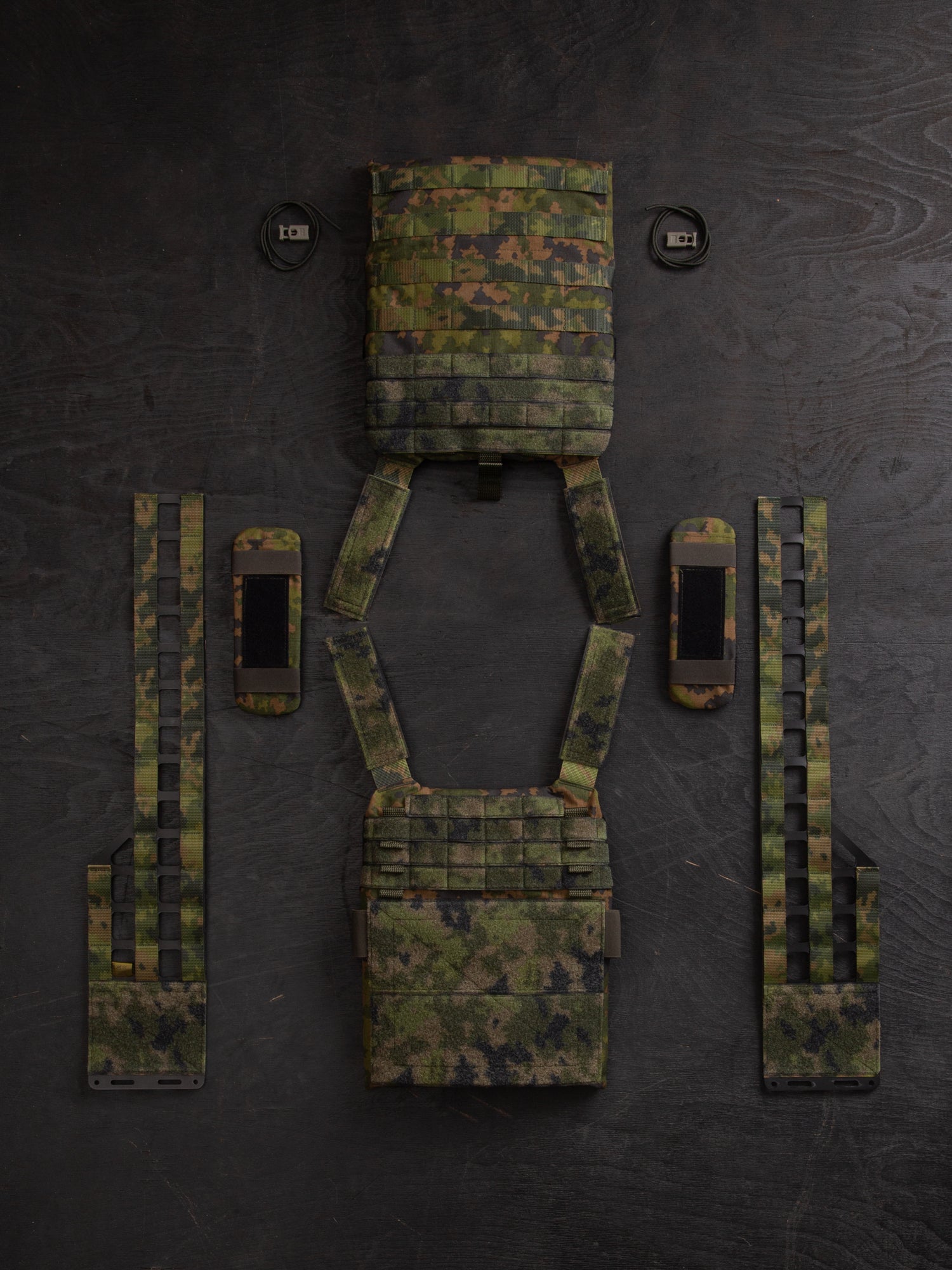 Savotta Varjelus plate carrier all parts spread out on a dark wooden surface