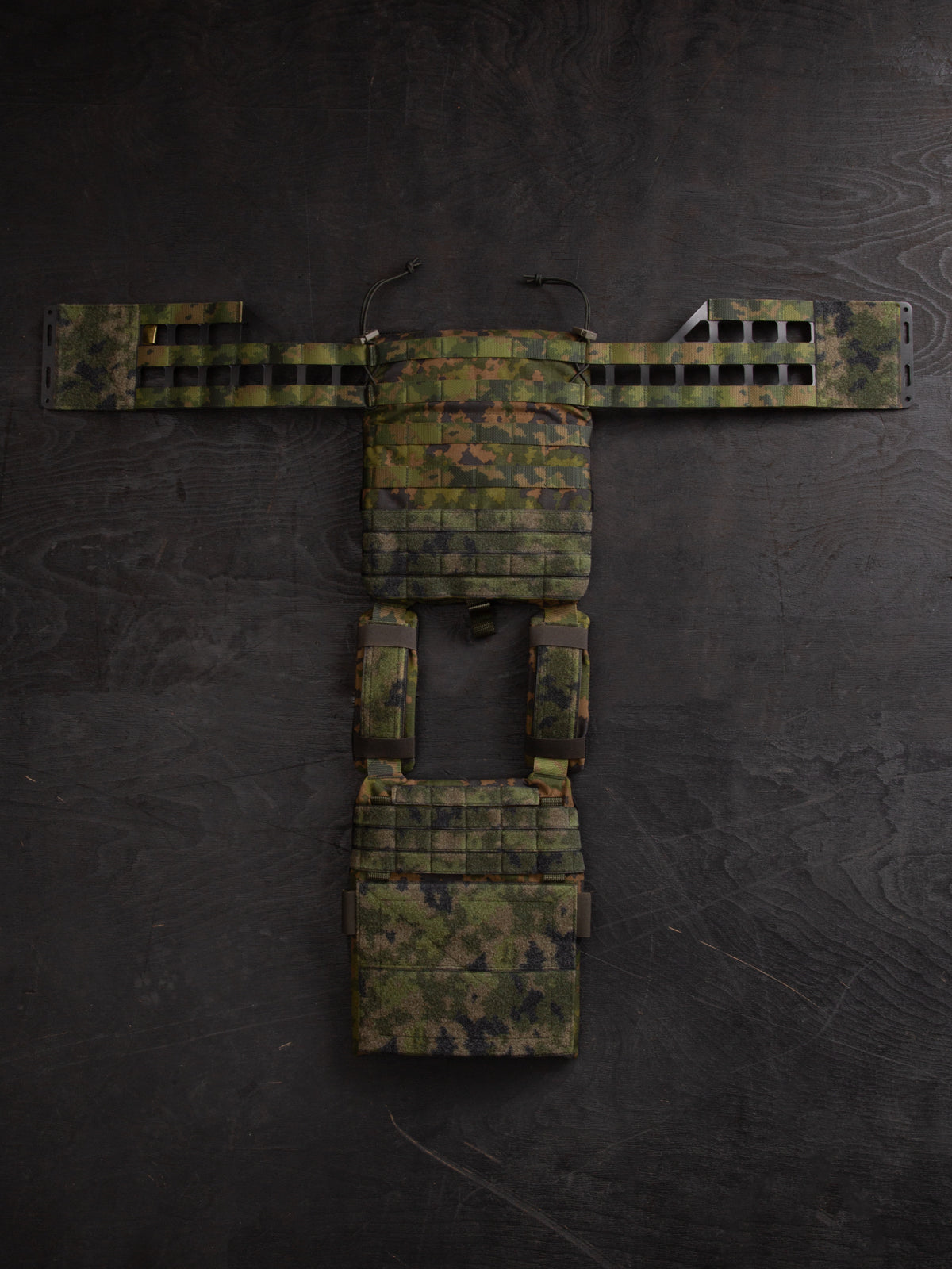 Savotta Varjelus plate carrier with cummerbunds attached, spread open a dark wooden surface