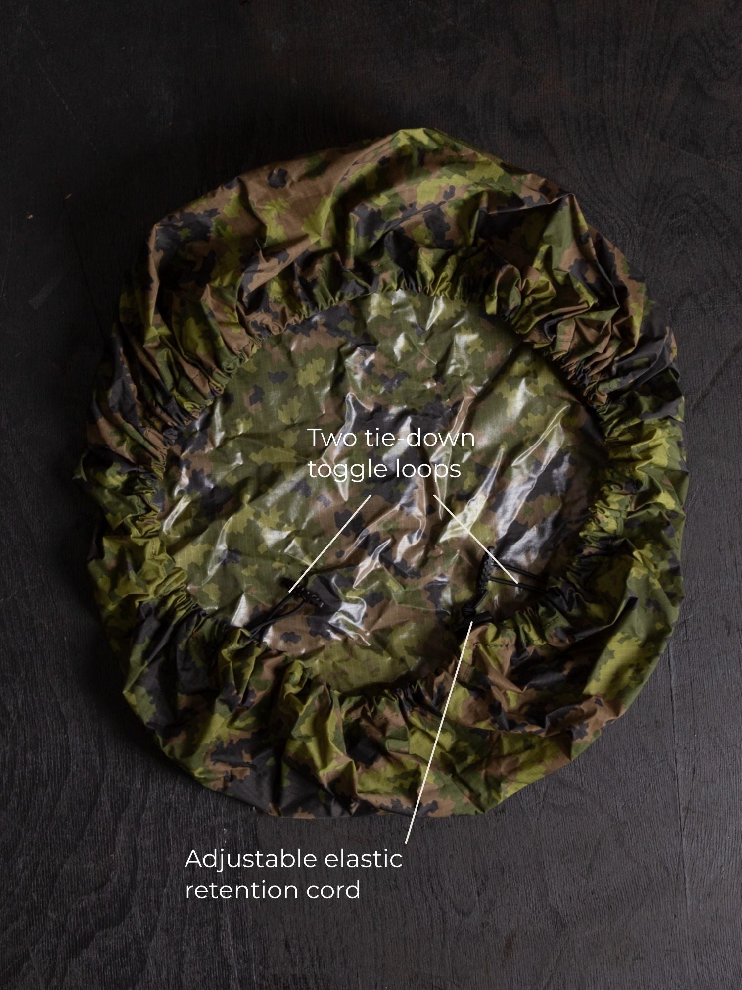 Savotta backpack cover IRR 30L lying on a dark wooden surface.