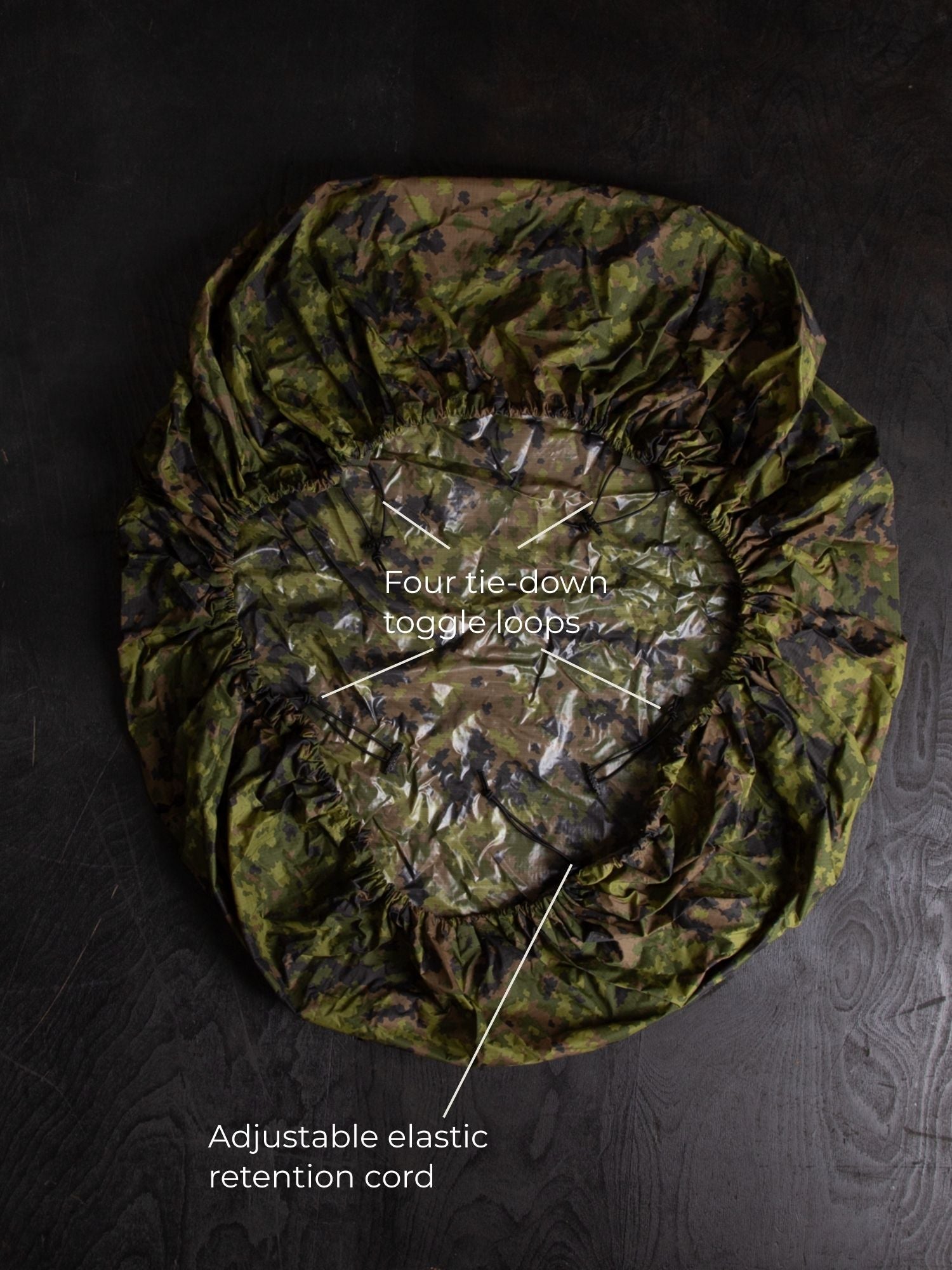 Savotta backpack cover IRR 80L lying on a dark wooden surface.