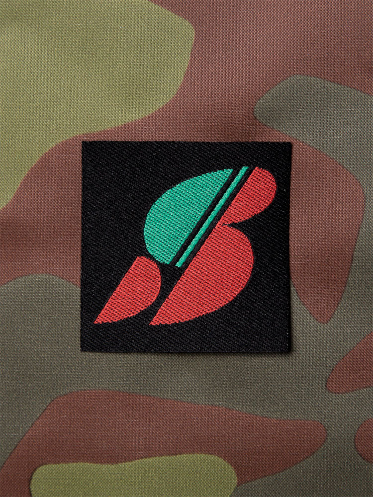 Colorful S-letter logo patch on a camouflage background