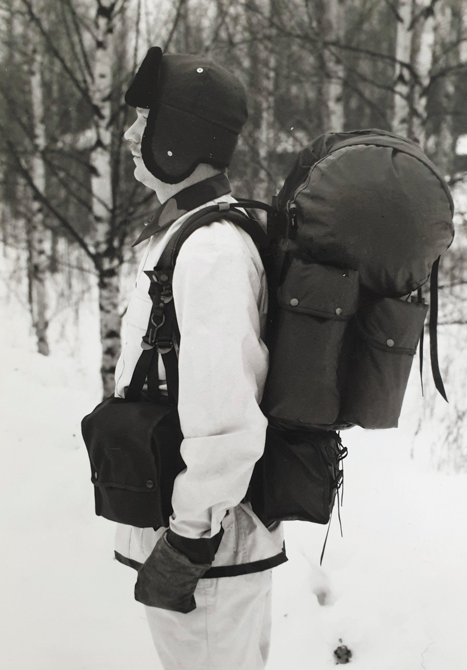 Person in winter clothing with a large Savotta backpack in a snowy forest.