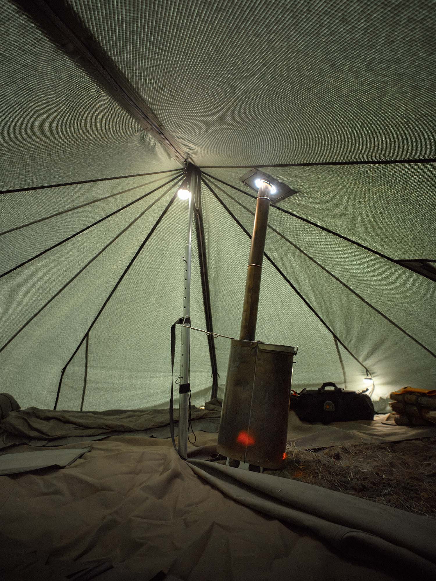 Savotta Hawu 8 tent interior with a portable stove and lighting setup