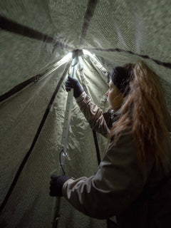 Person inside Savotta Hawu 8 tent setting up the center pole