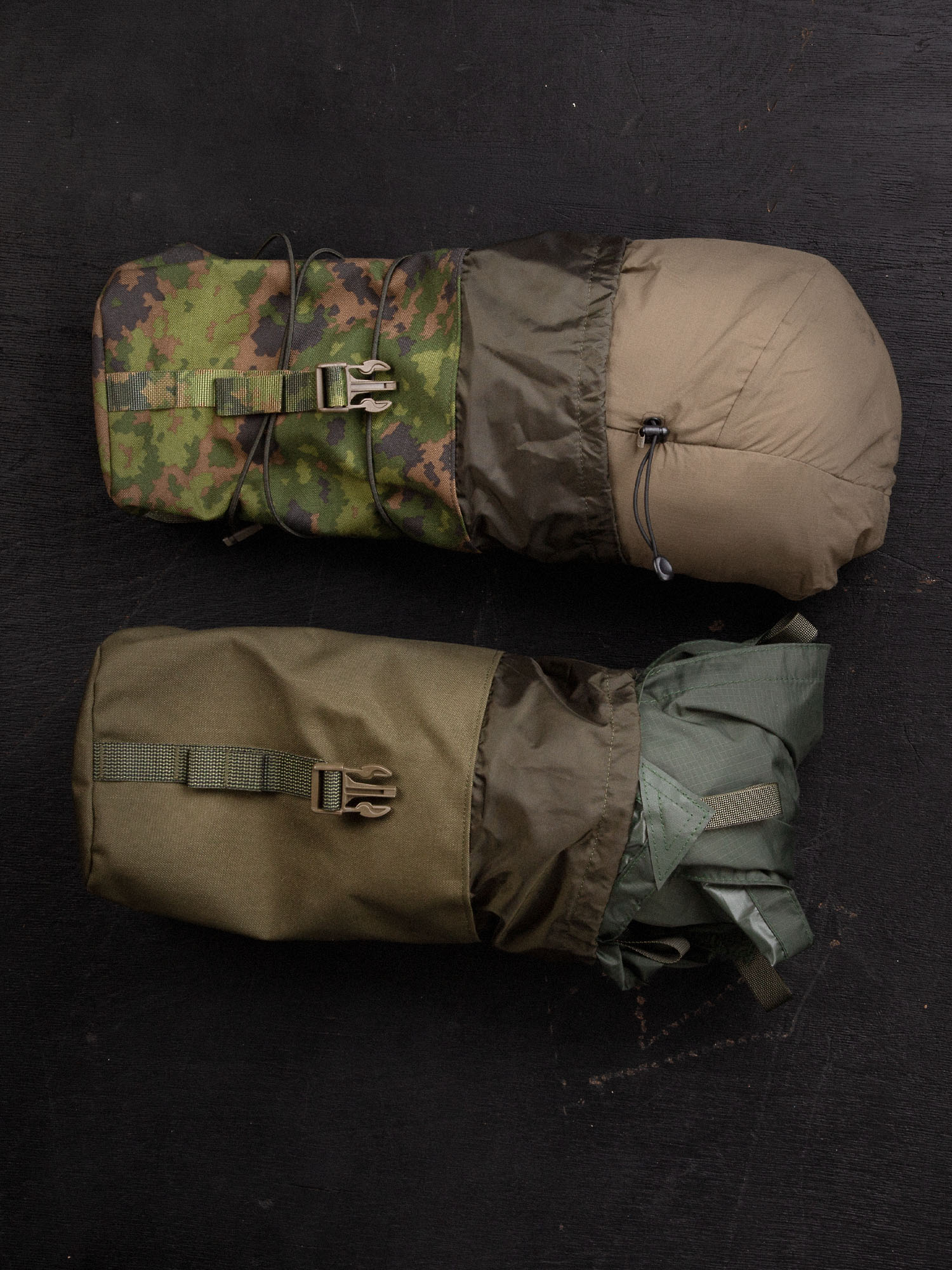 Two Savotta Lidded GP pouches 4x5 on a dark surface. One containing a belay jacket and the other a tarp.