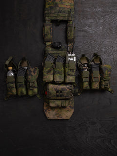 Savotta Varjelus PALS placard and different Savotta mag pouches attached to the Varjelus plate carrier which is being spread out on a dark wooden background.