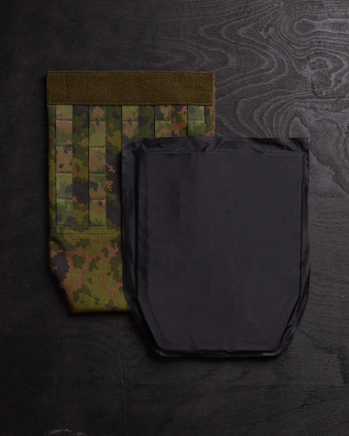 Savotta groin flap and a Savotta Sioen 25x30cm NIJ IIA panel next to each other on a dark wooden surface