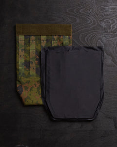 Savotta groin flap and a Savotta Sioen 25x30cm NIJ IIA panel next to each other on a dark wooden surface