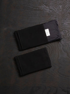 Two Savotta Varjelus side armour bags with Sioen 22,5x14 cm NIJ IIA panels inside of them, on a dark wooden surface