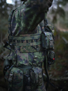 Side profile of soldier wearing a Savotta plate carrier in a forest
