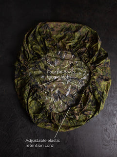 Savotta backpack cover IRR 80L lying on a dark wooden surface.