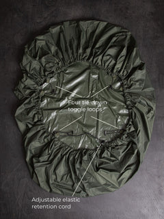 Savotta backpack cover 80L lying on a dark wooden surface with labels