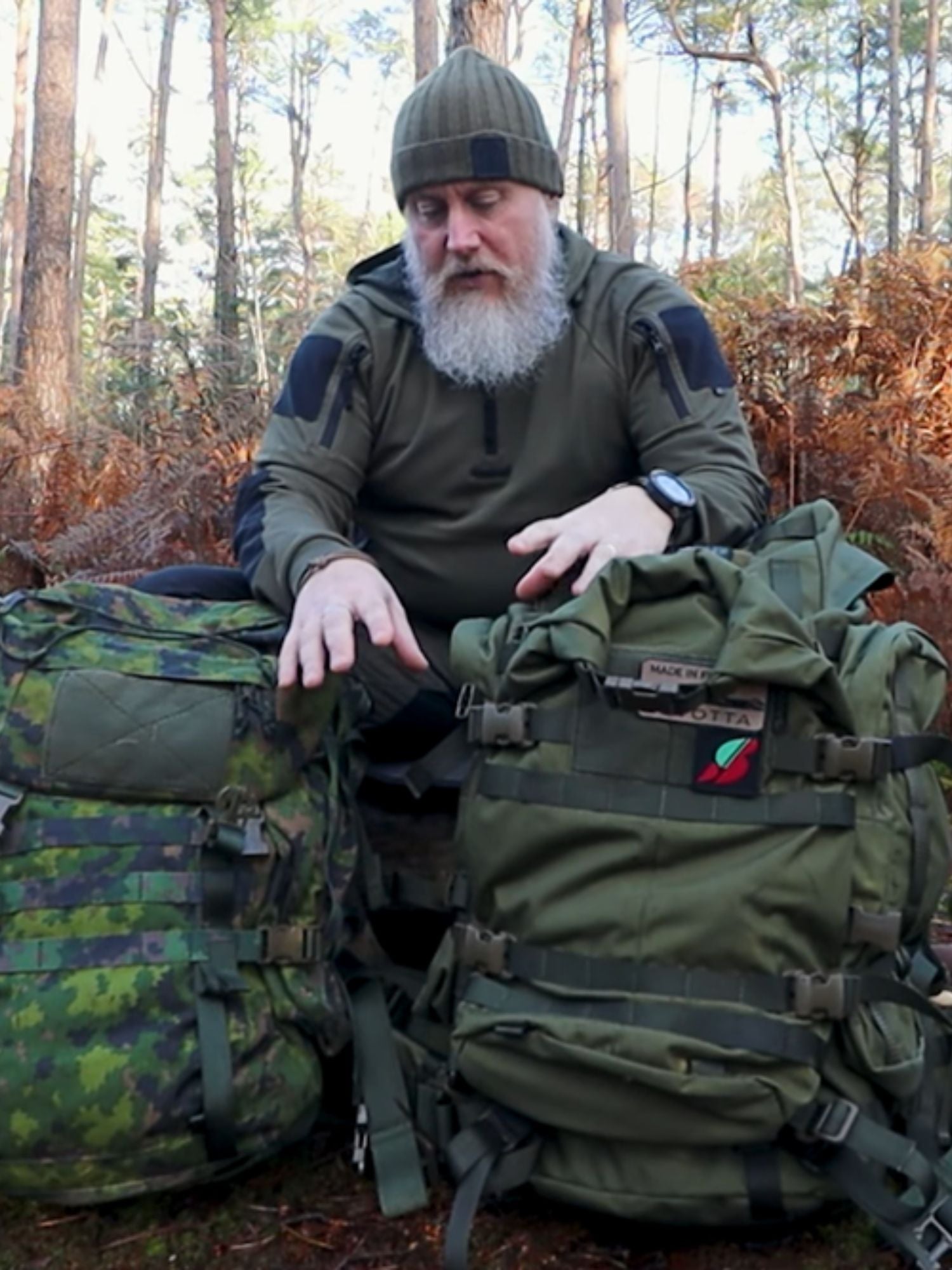 Man with a Savotta Kantamus 40L backpack and a Savotta Jääkäri L backpack in front of him in a forest